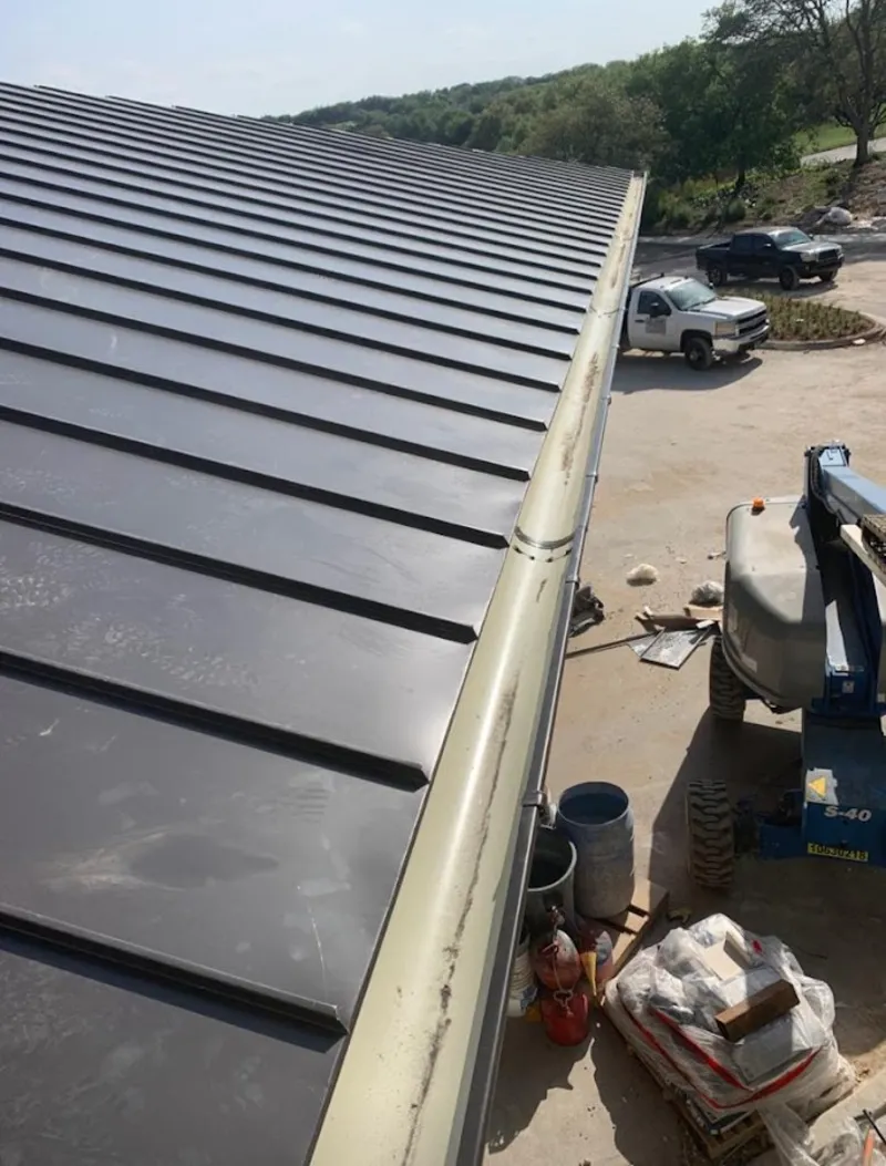 Standing seam panel and gutter detail on a metal roofing jobsite in Monticello
